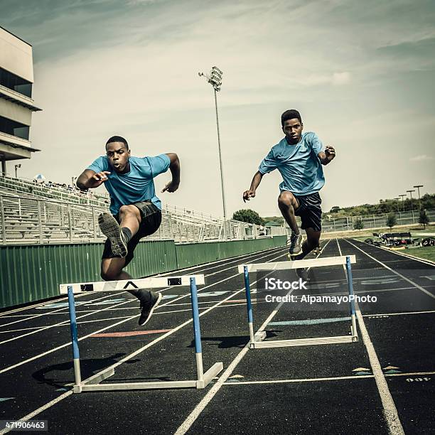 Young Hurdle Runners Compete At The High Scool Race Stock Photo - Download Image Now