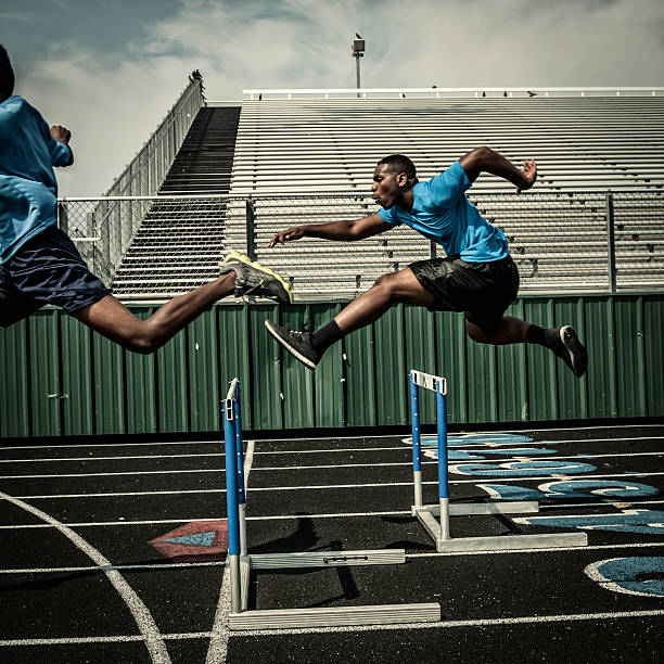 Senior Asian athlete is practicing hurdling running in the professional blue track for professional exercise, sport training workout and healthy for longevity concept