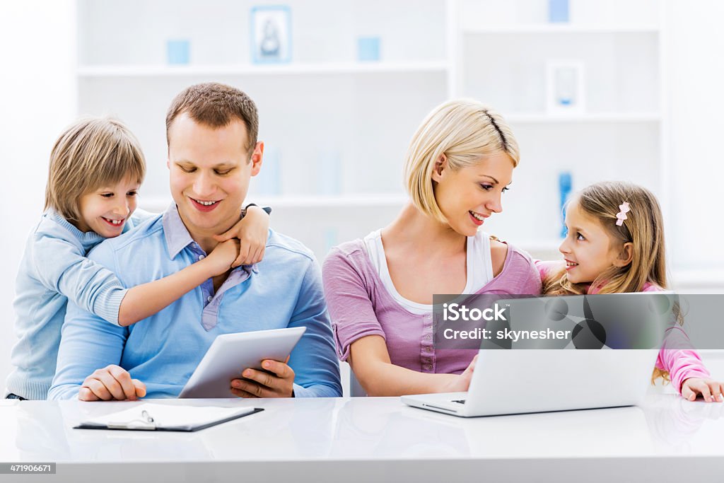 Familia utilizando la tecnología inalámbrica. - Foto de stock de Abrazar libre de derechos