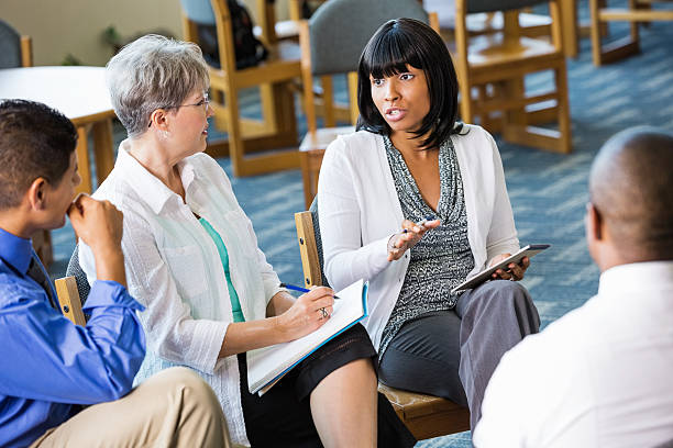 istock Woman discussing issue with senior counselor and support group 471907415