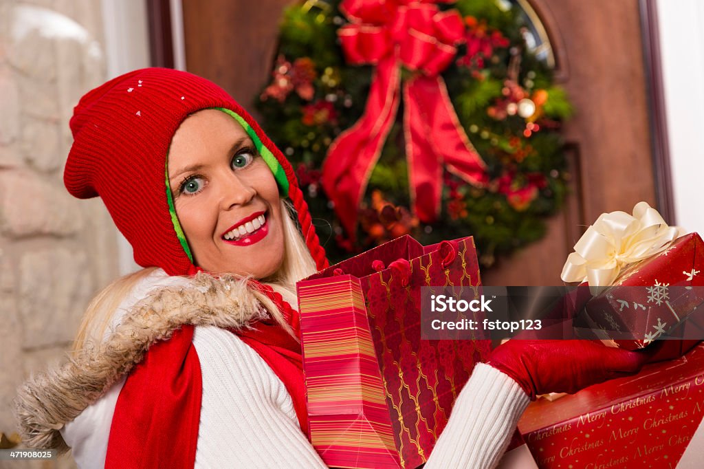 Noël: Femme met de nombreux cadeaux chez soi après une journée de shopping. - Photo de Acheter libre de droits