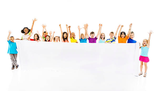 Large group of cheerful children holding white banner.