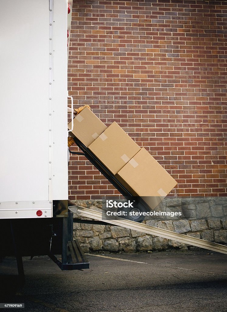 Delivery A courier unloading packages from a delivery truck.  Hand Truck Stock Photo