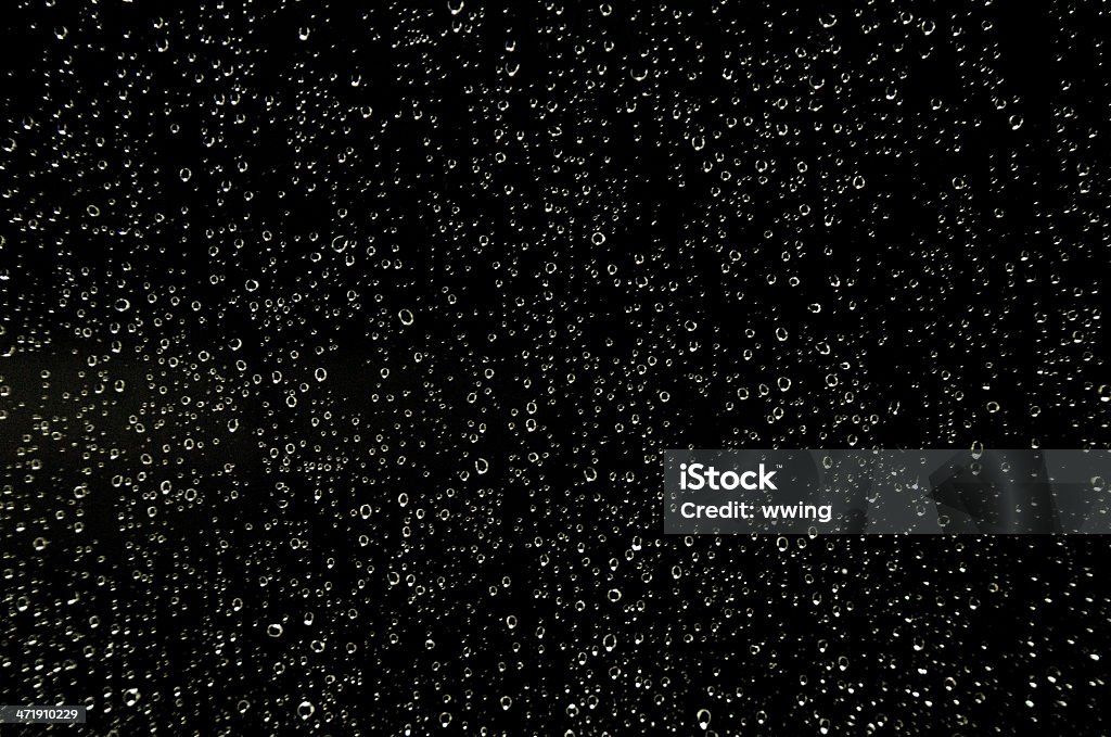 Night Rain Shower Raindrops on a window an night. Black background. Drop Stock Photo