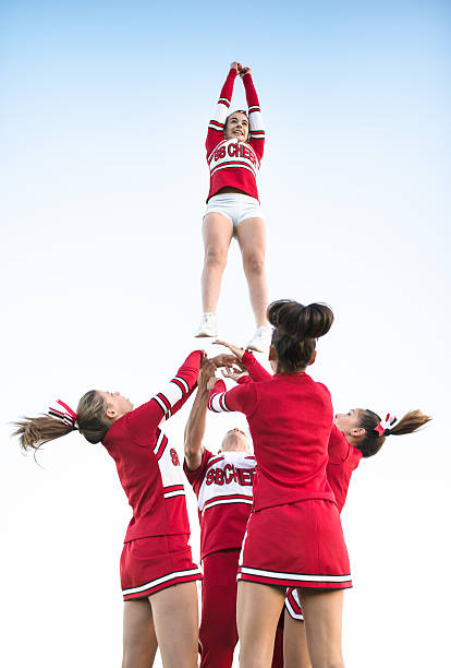 chefe de claque de lançamento de uma menina no ar - arms outstretched teenage girls jumping flying imagens e fotografias de stock