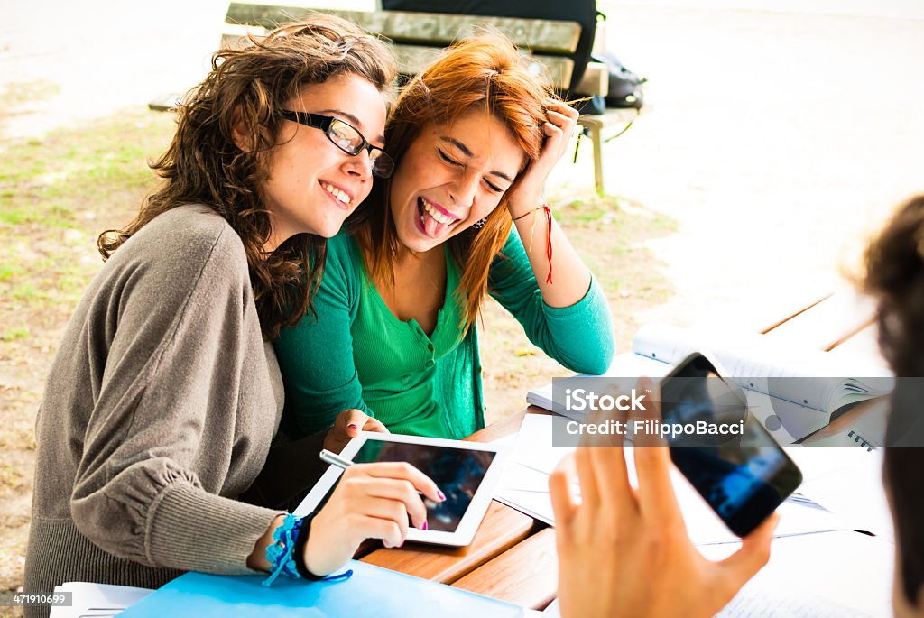 One young man take a picture of two friends One young man take a picture of two friends with smart phone. Adolescence Stock Photo