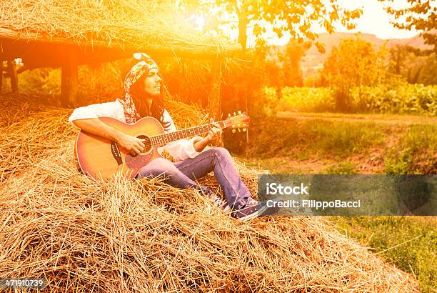 Jovem Hippie Homem A Tocar Guitarra Em Um Fardo De Feno - Fotografias de stock e mais imagens de 1960-1969