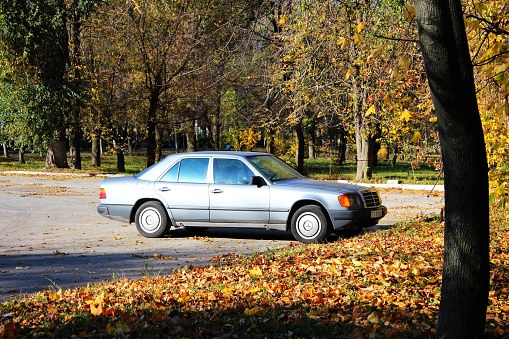 Chisinau, Moldova - October 20, 2013: A photo of parked grey Mercedes Benz 260E (W124) by autumn at sunny day. W124 is the Mercedes-Benz internal chassis-designation for the 1985 to 1995/6 version of the Mercedes-Benz E-Class.
