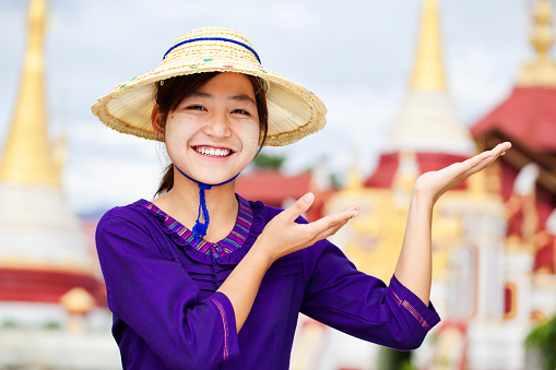 A portrait of a charming young Thai-Asian woman in a traditional Thai-Northern dress is in a beautiful temple. Thai culture, Buddhism, cultural travel, and lifestyle, full body picture