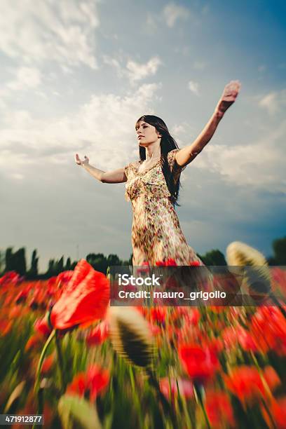 Hermosa Mujer En Campo De Amapolas Foto de stock y más banco de imágenes de Alzar los brazos - Alzar los brazos, Amapola - Planta, Campo - Tierra cultivada