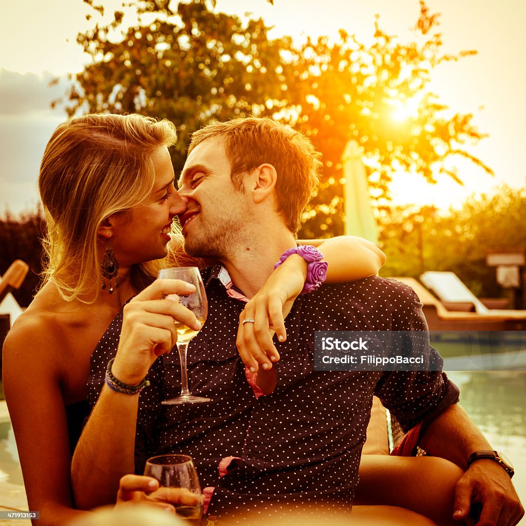 Young couple having aperitif near the swimming pool Auto Post Production Filter Stock Photo
