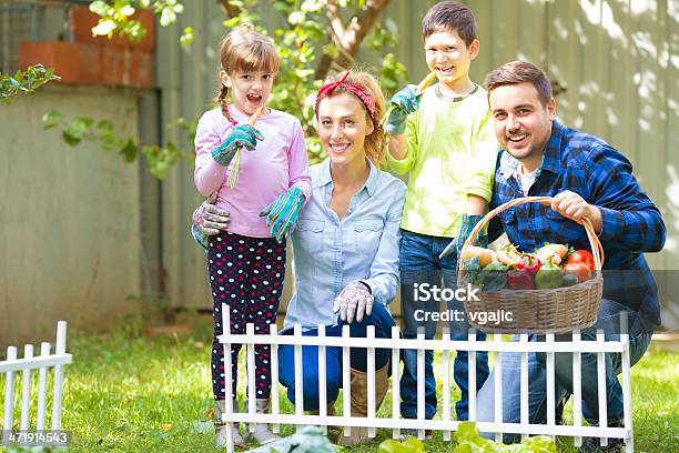 Family Working At Vegetable Garden Stock Photo - Download Image Now - 25-29 Years, 6-7 Years, Adult