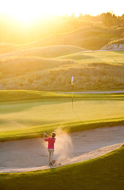 junior golfista utrafiając bunker ujęcie - utrafiając zdjęcia i obrazy z banku zdjęć