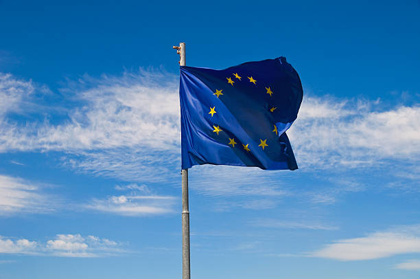 A torn EU flag blows in the wind with a few clouds in the background, seen in Pevensey Bay, East Sussex, England, UK