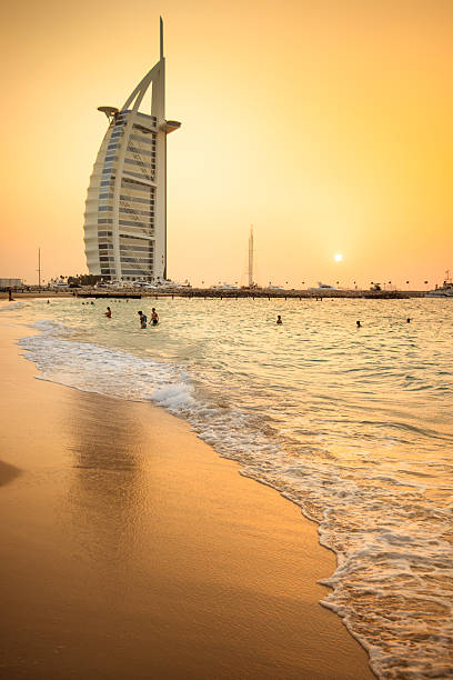 Dubai, UAE - October 30, 2014:  View of the Burj Al Arab at dusk. It is a 7 stars hotel and one of the most luxury hotel on the world. Image taken at sunset. Some tourist are still on the water at the sunset.