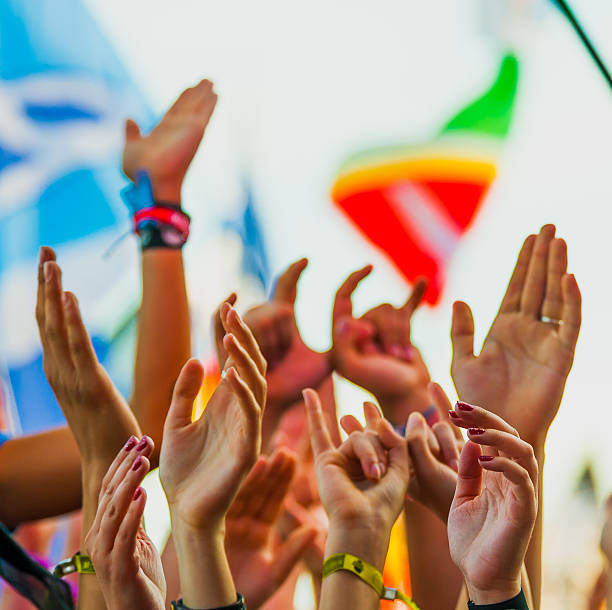 istock Hands reaching toward the sky at a rock festival with flags 471918270