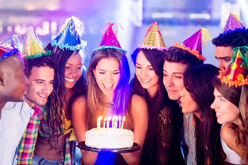 Group of people in a birthday party about to blow the candle