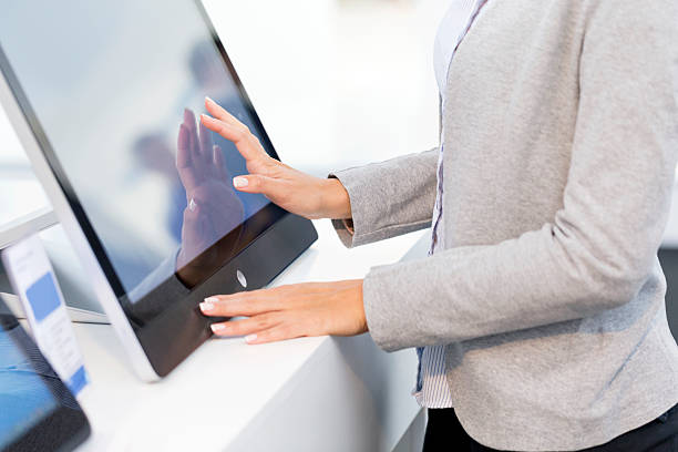 A woman using a touch screen computer Unrecognizable woman shopping for touch screen computer in electronics store, copy space computer shop stock pictures, royalty-free photos & images