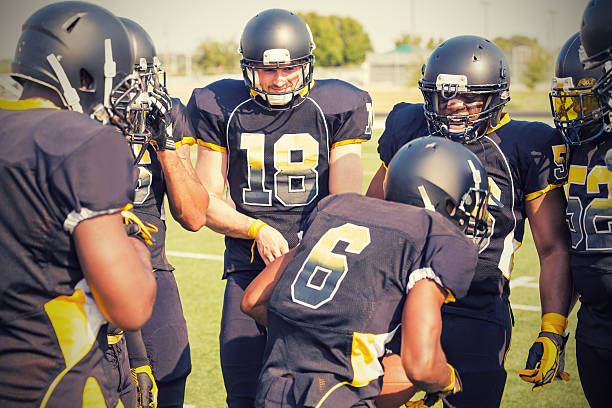 istock Professional football team deciding play on field sidelines 471920481