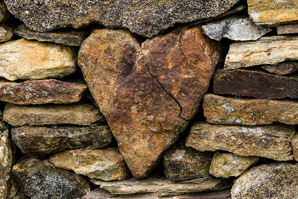 corazón en la frontera de piedra - piedra roca fotografías e imágenes de stock