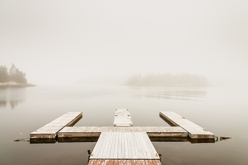 Jetty and calm lake on a foggy autumn day. Halifax, Nova Scotia, Canada.