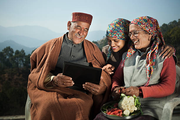 menschen himachal pradesh: alter mann mit laptop mit ihrer familie. - indian culture family senior adult asian ethnicity stock-fotos und bilder