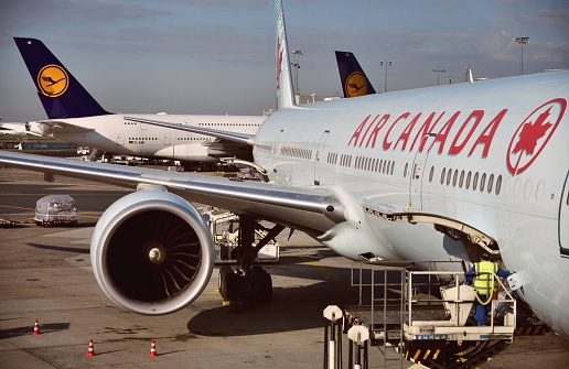 Frankfurt, Germany - April 18, 2015: An Air Canada Boeing preparing for the flight to Toronto with Aircrafts of Star Alliance Partner Lufthansa taxiing in the background.