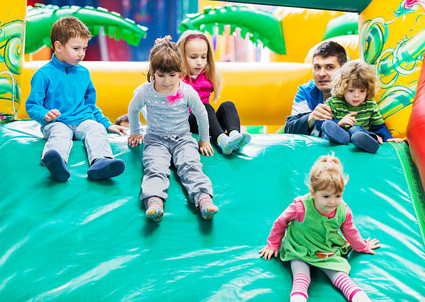 enfants sur un toboggan aquatique gonflable. - inflatable child playground leisure games photos et images de collection
