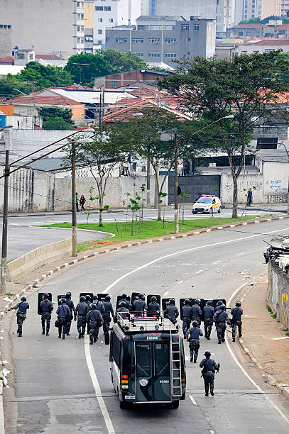 Riot squad São Paulo, Brazil, November, 01, 2013:Police riot squad in formation to hold a demonstration against the eviction of a slum in the north of the city of São Paulo in Brazil. Since June there has been constant demonstrations in major Brazilian cities by improvements in the infrastructure and policy transparency riot police stock pictures, royalty-free photos & images