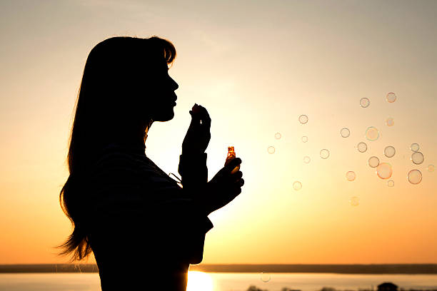 istock beautiful young girl blow bubbles on nature 471925432