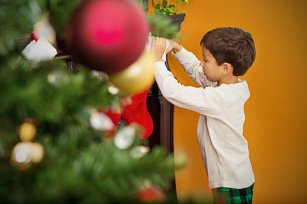 feliz rapaz olhando para meia de natal de manhã - christmas child little boys peeking imagens e fotografias de stock