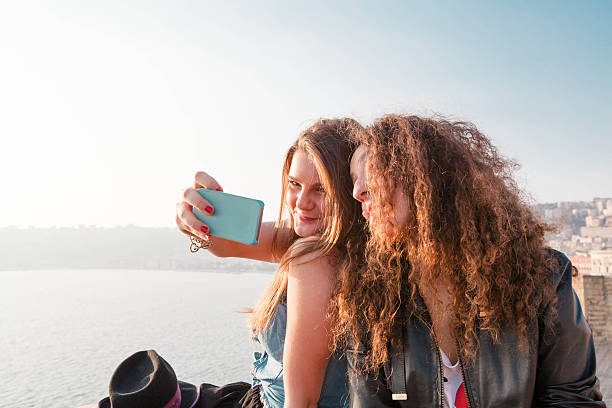 istock Two Girls Enjoying with a Smartphone at Sunset 471926251