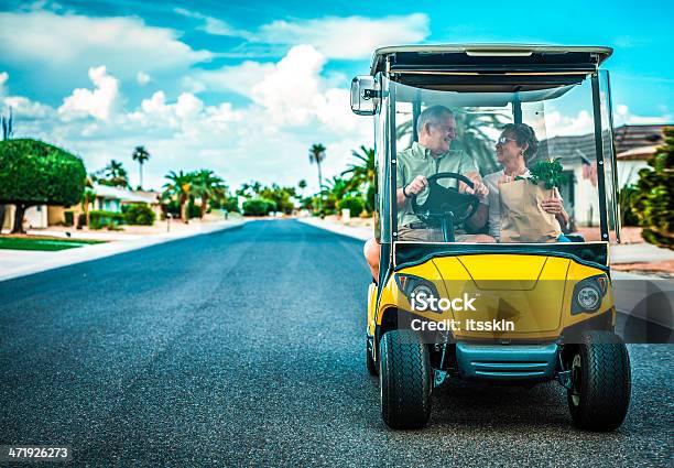 Senior Couple Returning Home After Shopping Stock Photo - Download Image Now - Golf Cart, Street, Senior Couple