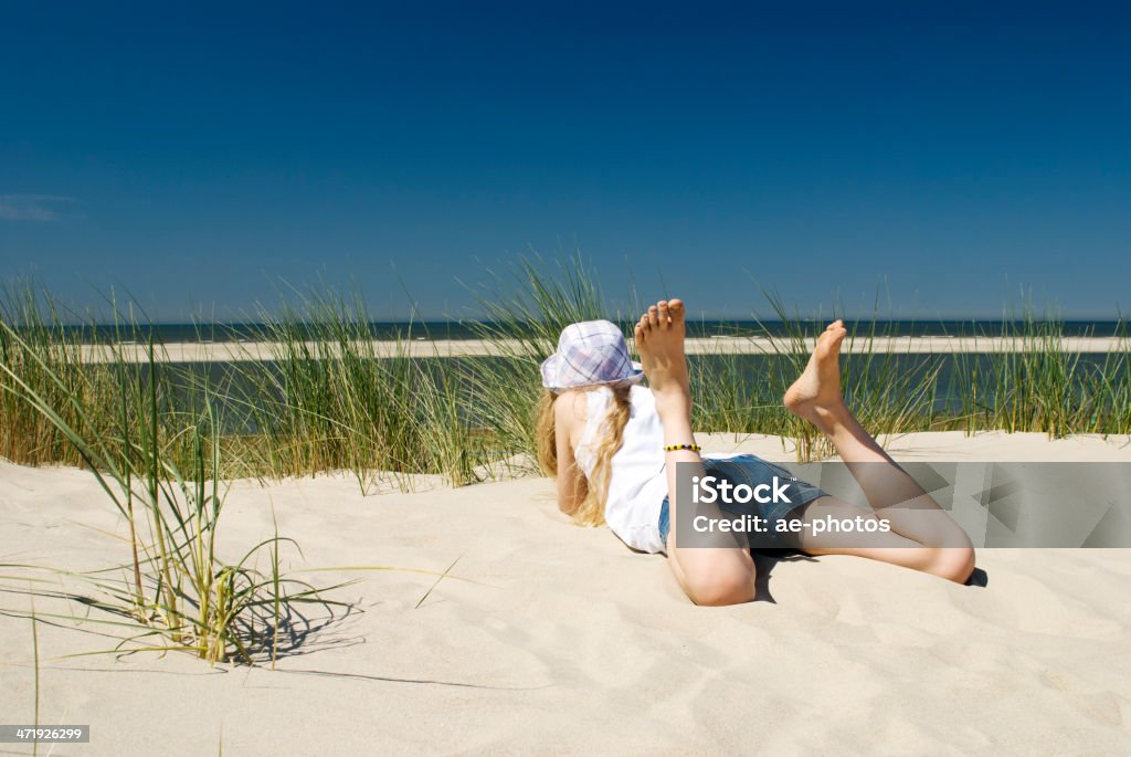 Chica relajante en la Duna de arena del profundo mar azul - Foto de stock de Acostado libre de derechos