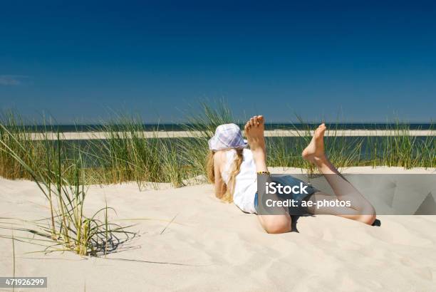 Chica Relajante En La Duna De Arena Del Profundo Mar Azul Foto de stock y más banco de imágenes de Acostado