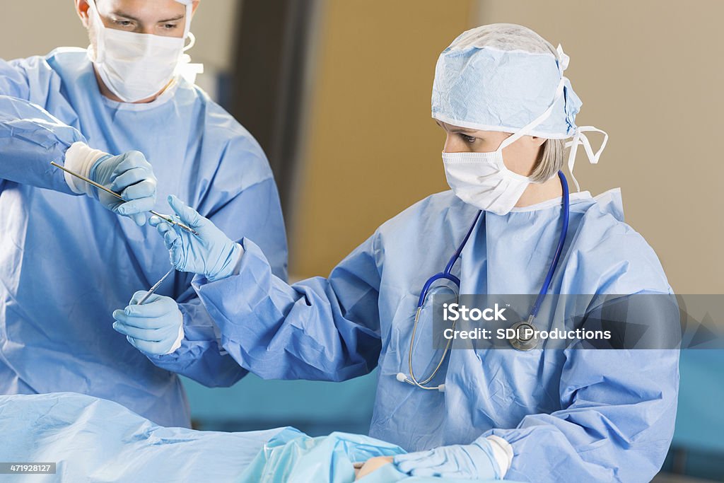 Surgical technician handing instruments to surgeon in operating room Accidents and Disasters Stock Photo