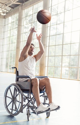 Disabled basketball player throwing the ball at the court