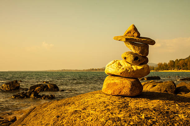 pilha de pedras sobre uma grande rocha na praia. - stack rock stack stacking spa treatment - fotografias e filmes do acervo