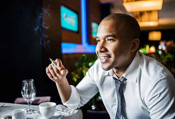 Businessman smoking cigar in a restaurant.