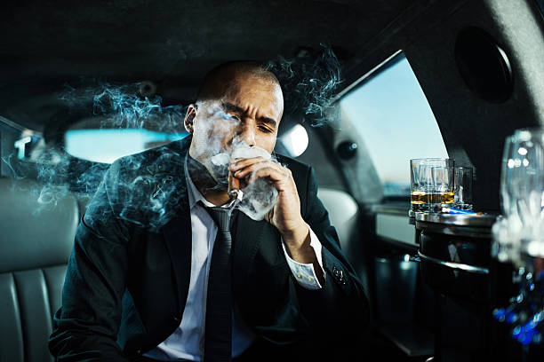 istock Businessman smoking a cigar in limousine. 471928961