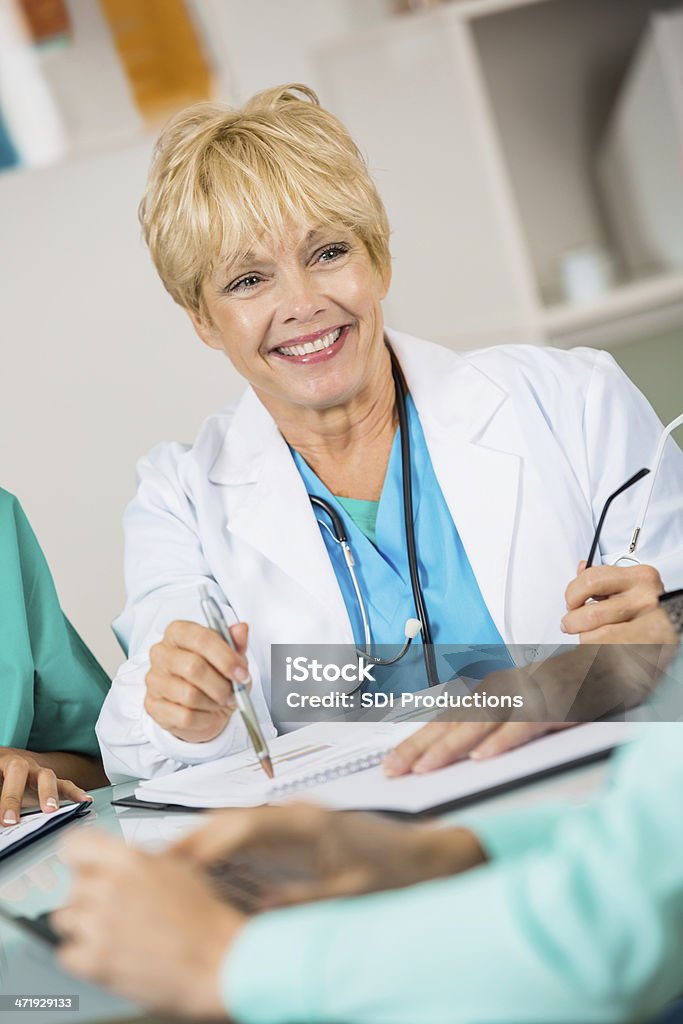 Senior doctor or nurse in hospital staff meeting Senior doctor or nurse in hospital staff meeting  Administrator Stock Photo