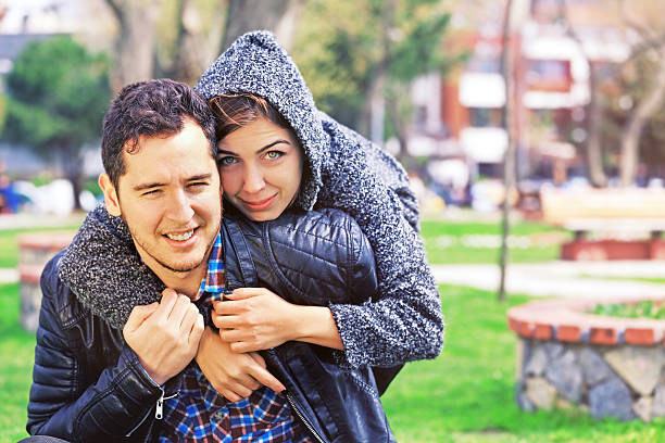 Young couple hugging in park.