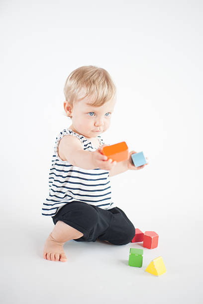 Baby girl playing with toys stock photo