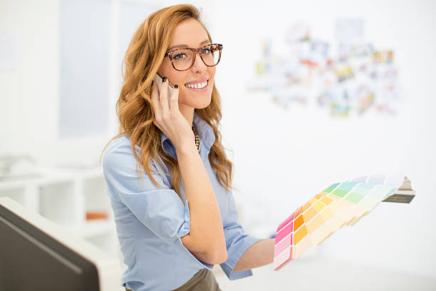 Female Designer Talking On The Phone At Work.