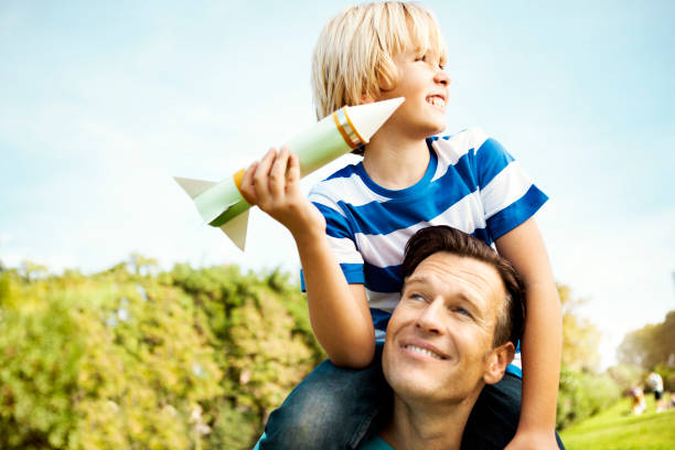 Boy and dad playing with rocket Boy and dad playing with rocket model rocket stock pictures, royalty-free photos & images