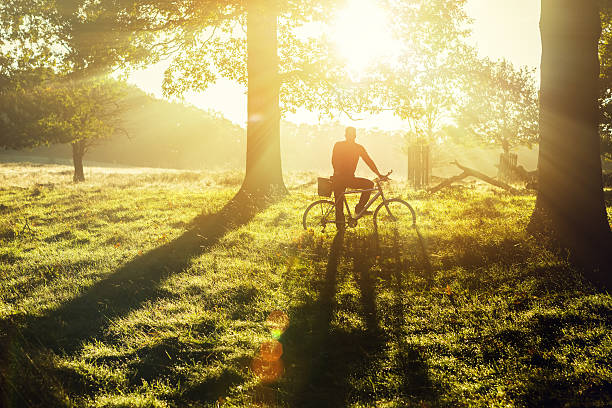 young man cycling in Richmond Park, London young man cycling in Richmond Park, London in the morning richmond park stock pictures, royalty-free photos & images