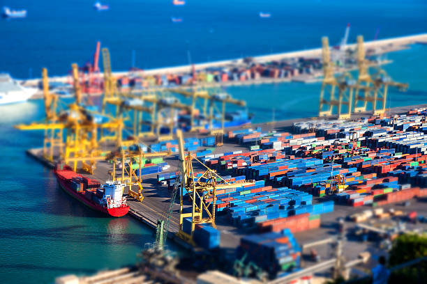 Aerial view of Barcelona harbor with containers, cranes and cargo ship.