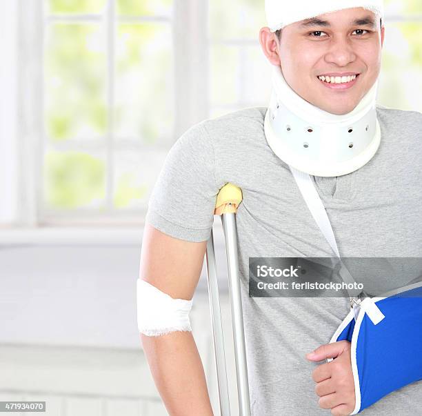 Injured Young Man Use Crutch And Arm Sling Stock Photo - Download Image Now - 2015, Adult, Adults Only