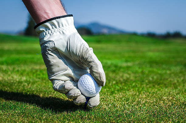 istock Hand with a glove is placing a tee with golf 471934236
