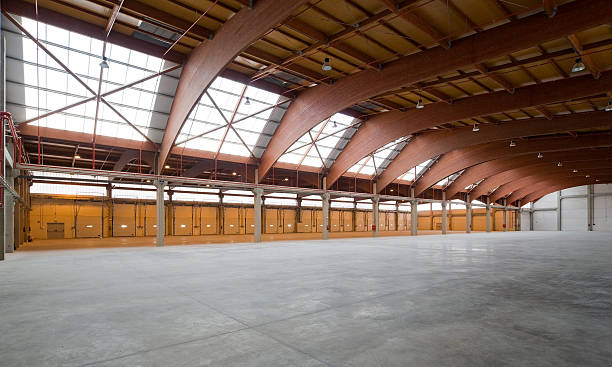 Ship industry Interior photograph of an industrial warehouse of laminated wood by roof and concrete floor, with skylights tornillo stock pictures, royalty-free photos & images